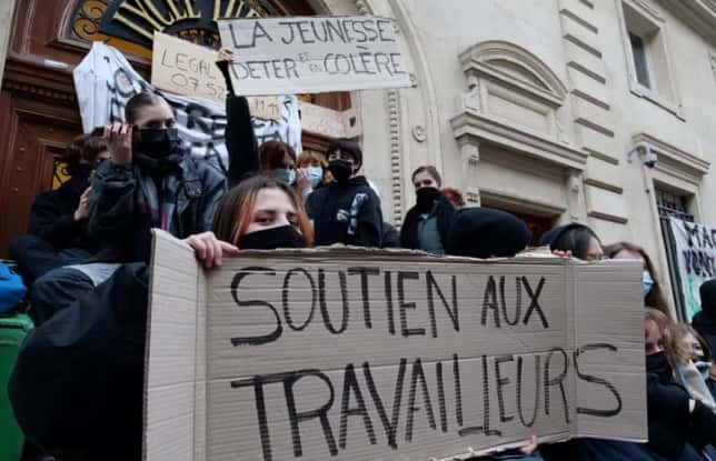 Estudiantes bloquean el ingreso a un liceo en París, con carteles de "Apoyo a los trabajadores" y "Juventud molesta".